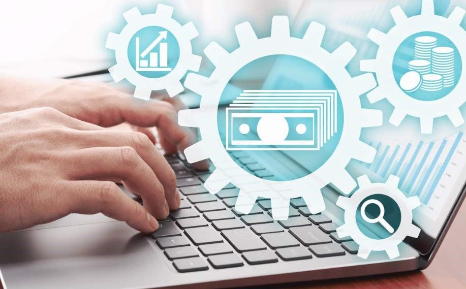 A person's hands typing on a laptop with digital icons of money, a graph, and a magnifying glass overlaid
